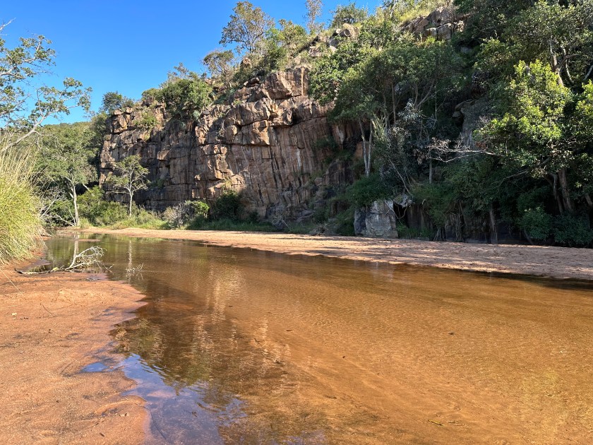 Welgevonden Game Reserve: strand en riviertje met rechts berghelling. 