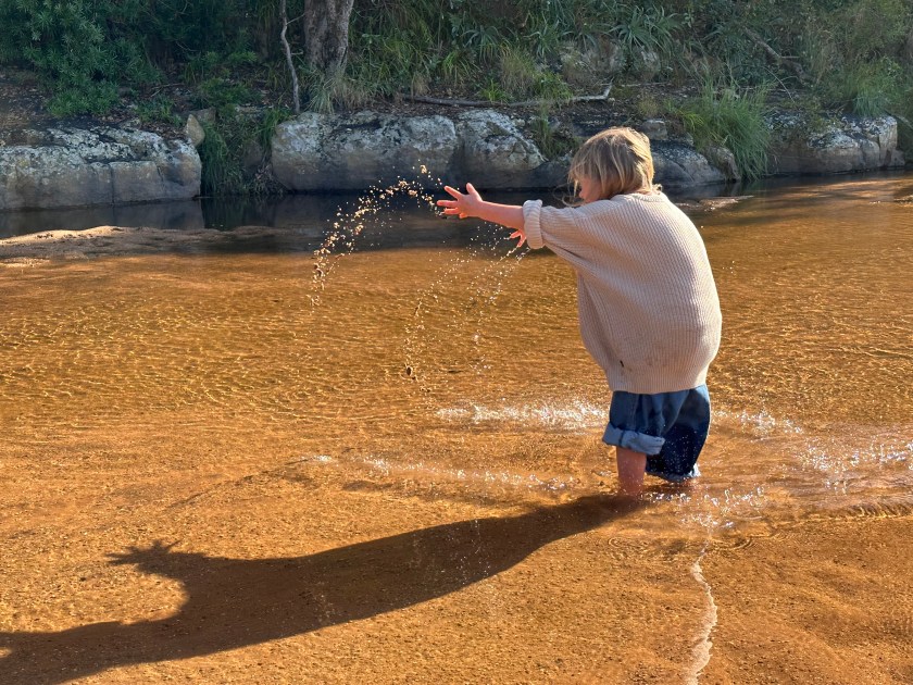 Welgevonden Game Reserve: kindje gooit met water in beekje. 