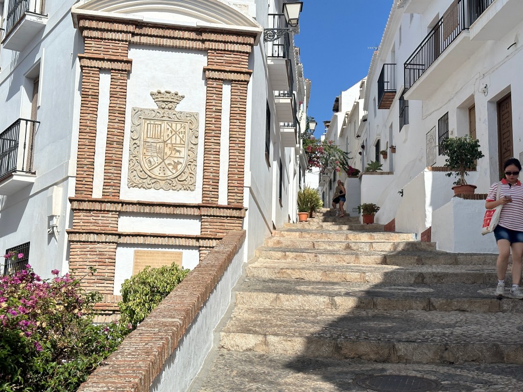Trappen naar de bovenstad met witte huizen rechts. 