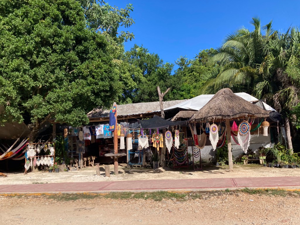 Primiteif winkeltje met stooien dak en golfplaten dak langs de weg. 