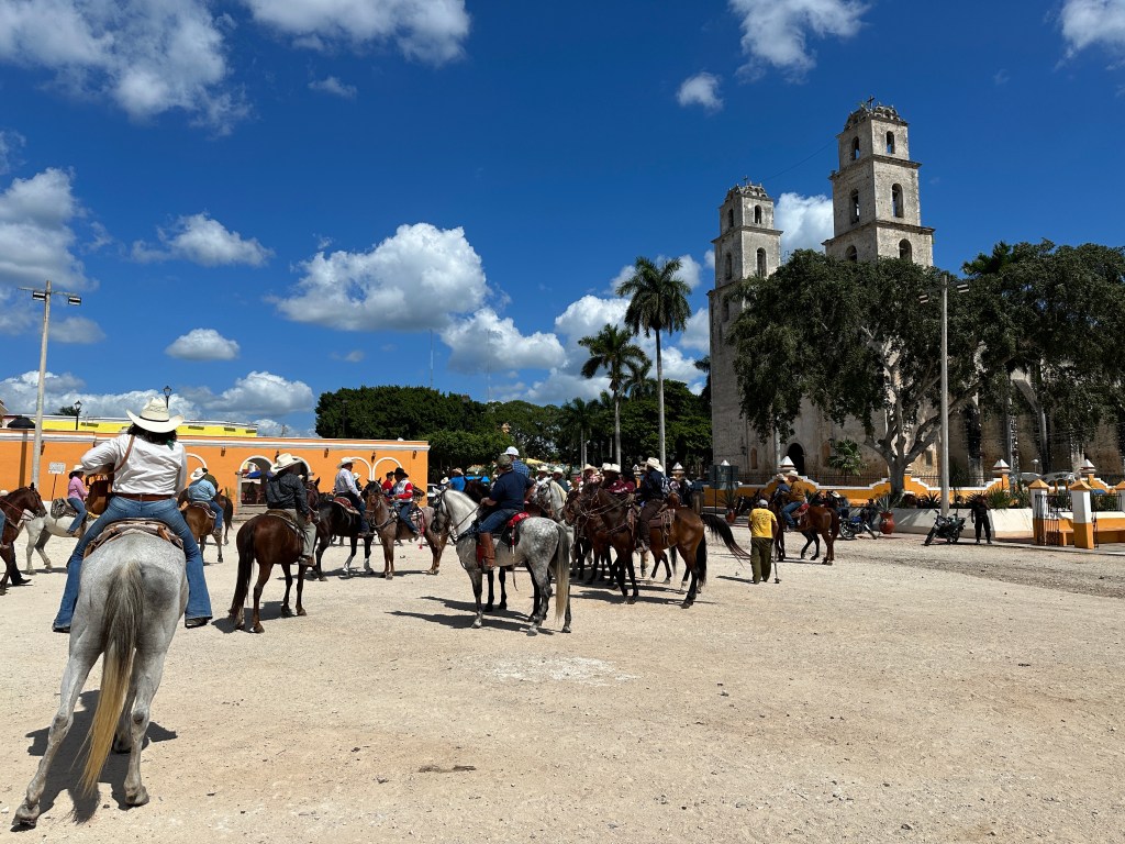 Paarden met ruiters met cowboy-hoeden op het centrale plein van Espita. 
