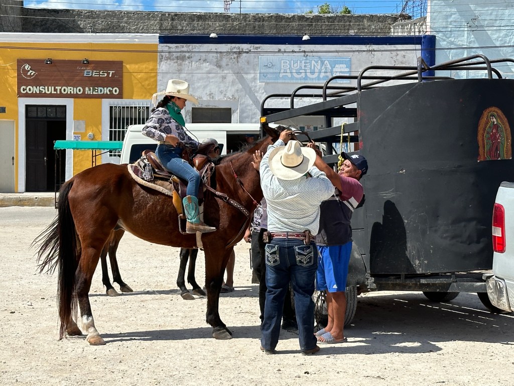 Cowboys tuigen paard van amazone af. 
