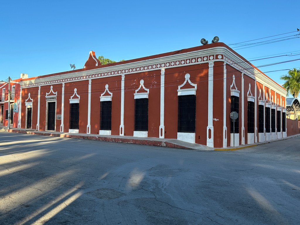 Bruinrood gebouw met witte biezen in Espita. 