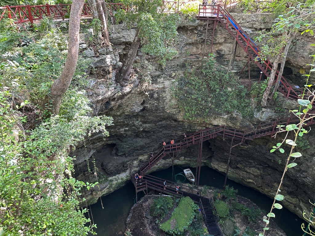 Chichikan cenote: houten trappen leiden naar de vloer van de cenote. 