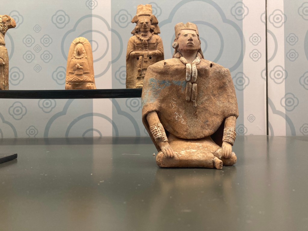 Bruine terracotta beeldjes van onder andere zittend persoon. 