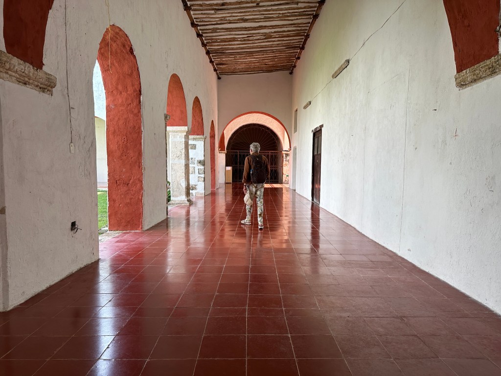 Witte kloostergang met rode vloer.  