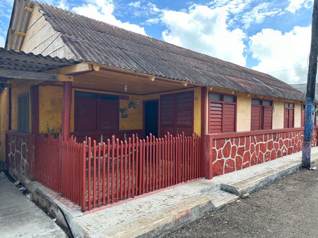 Beige huis, bruinrode luiken, deuren en afsluiting. 
