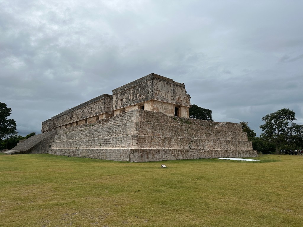 Vierhoekig gebouw met trappen als eerste verdieping en aparte gebouwen er boven. 
