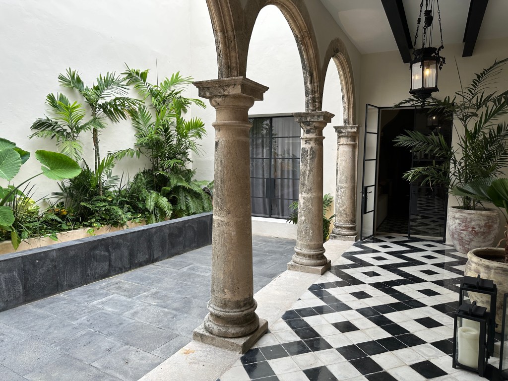 Bogen, pilaren, zwart-witte tegelvloerd: ingang van Casa Japa. 