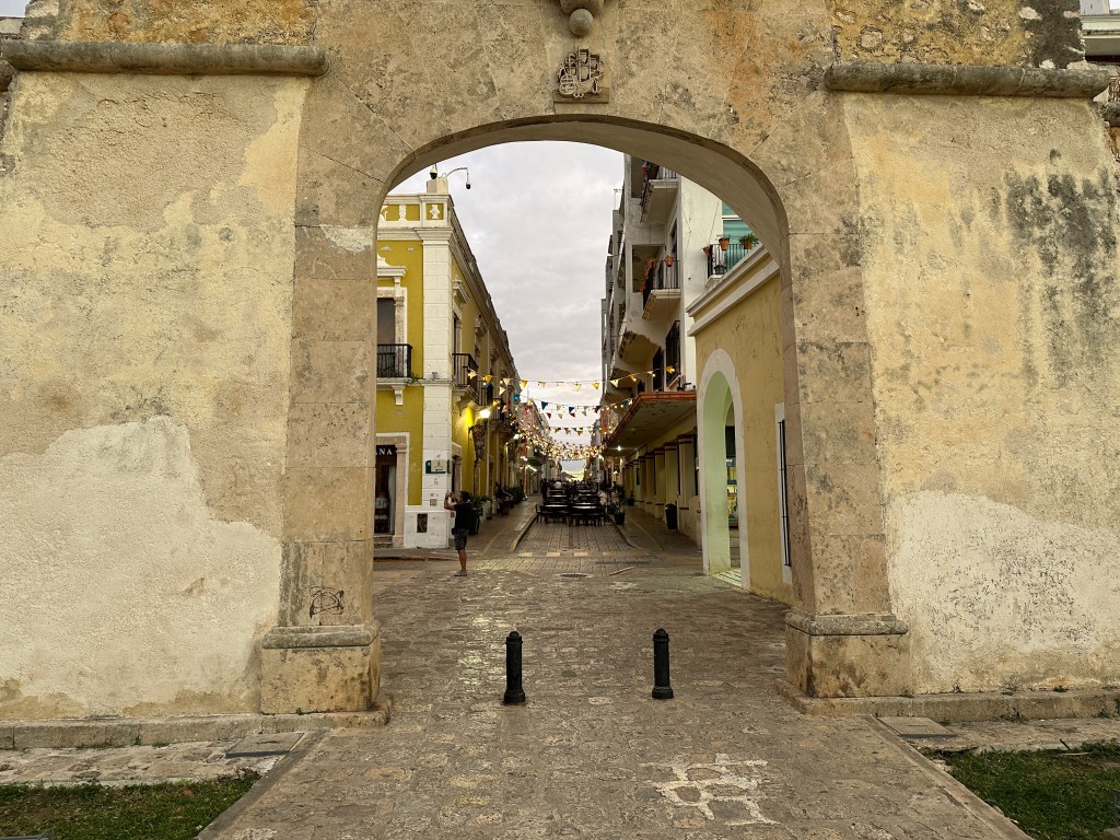 Muur met boog en lange straat in Campeche. 