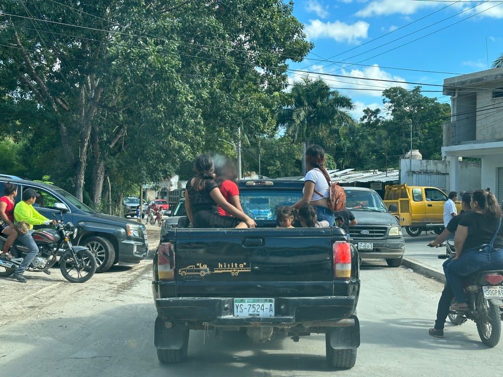 Verkeersopstopping in Chiná, Yucatan: Tieners in laadbak van truck. 