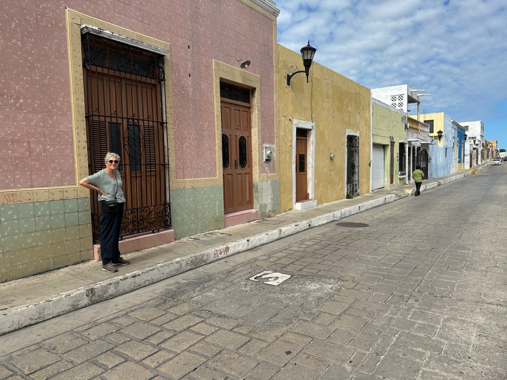 Toeriste voor poort van statige huizen in Campeche. 