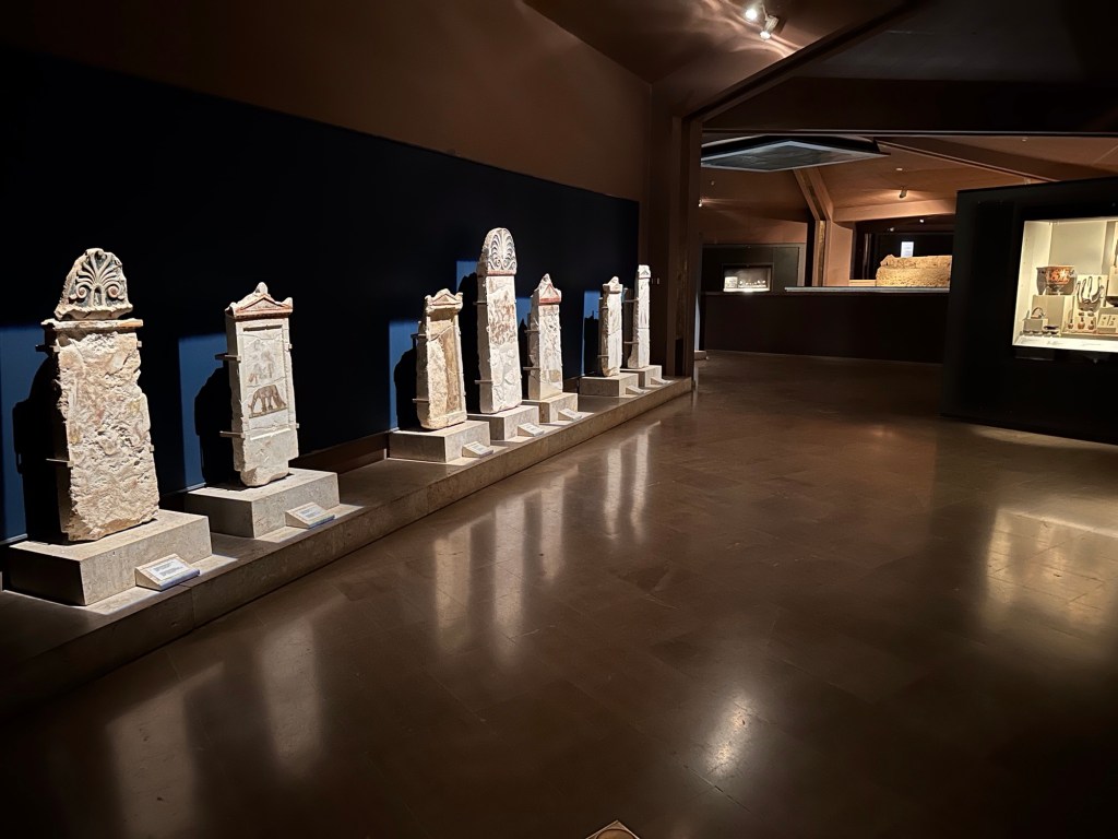 Koningsgraven, Aigai: rij verlichte grafstenen in donkere ruimte