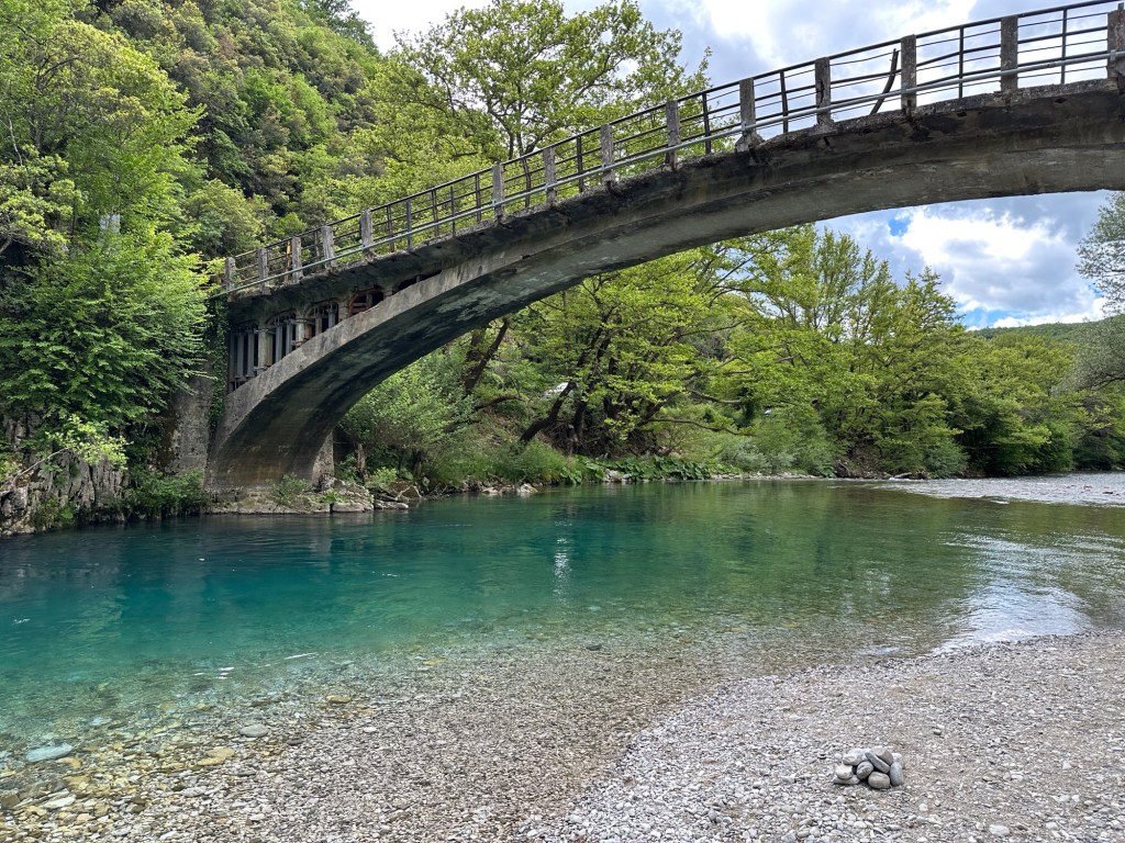 Boogbrug over de blauwgroene Voidomatis river