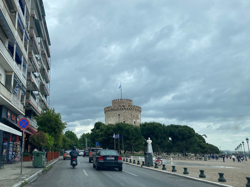 Straat met buildings en zee en ronde toren in achtergrond in Thessaloniki, Centraal Griekenland