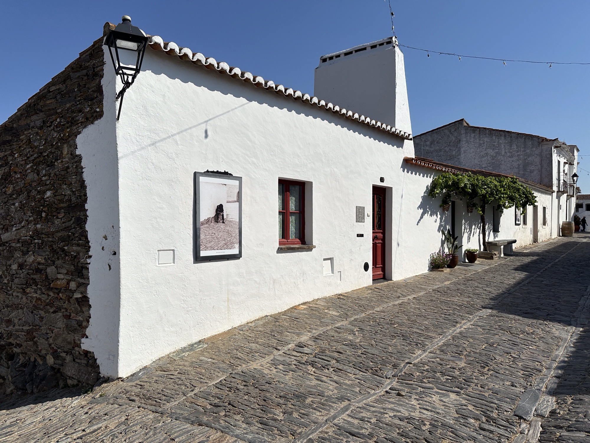 Wit huis met een foto van vroeger aan de gevel, Monsaraz, Alentejo