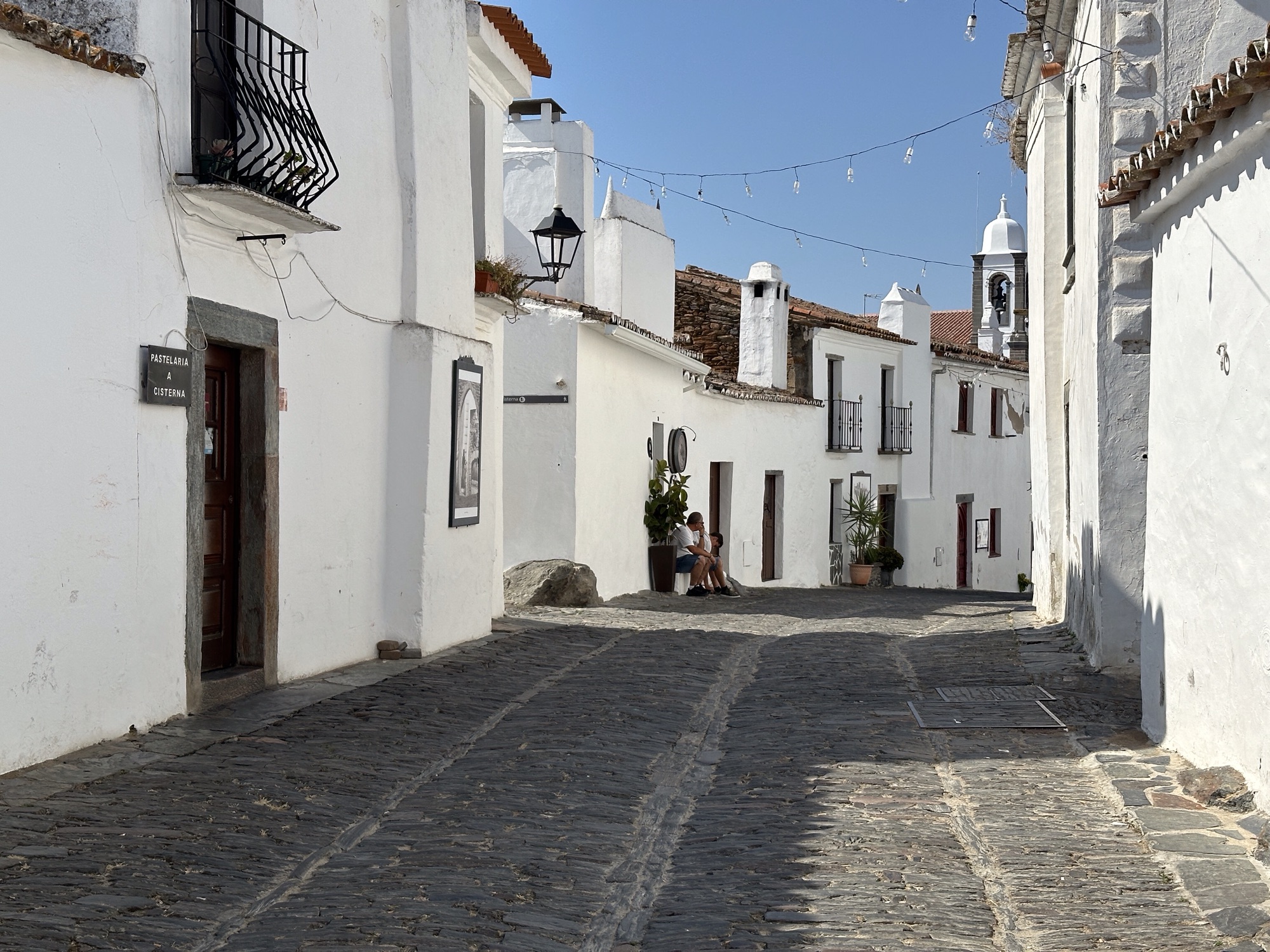 Bochtige smalle straat met witte huizen in Monsaraz, Alentejo