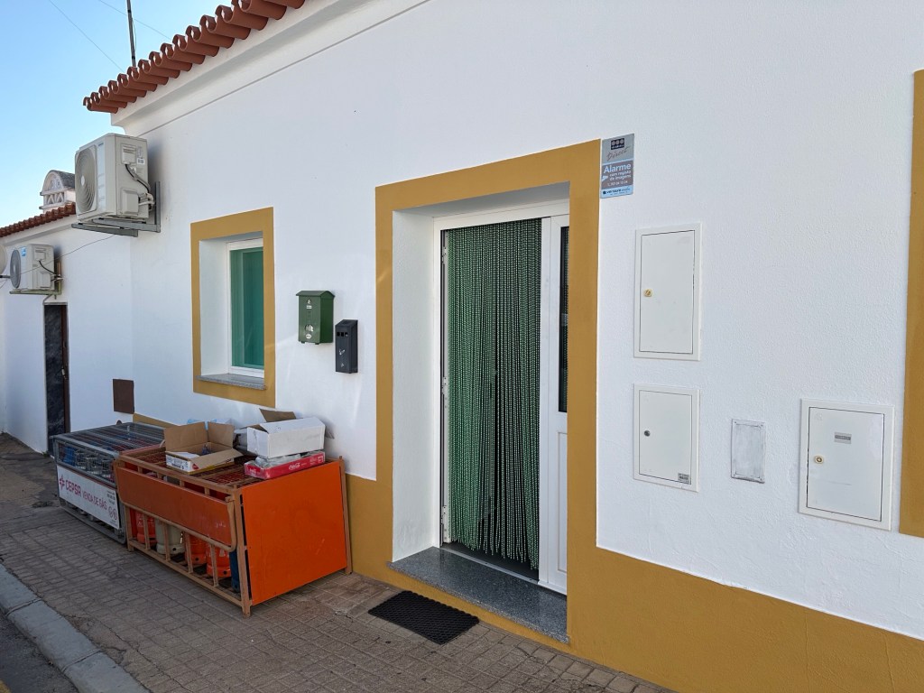 Wit huis, lege butaanflessen voor de gevel in Outeiro, Alentejo