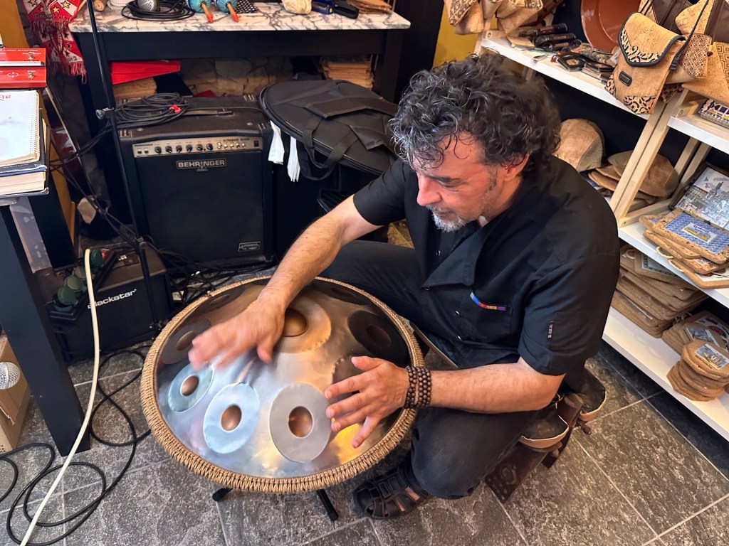 Pedras Do Castelo, Alentejo: man in ‘t zwart bespeelt een handpan, rond instrument