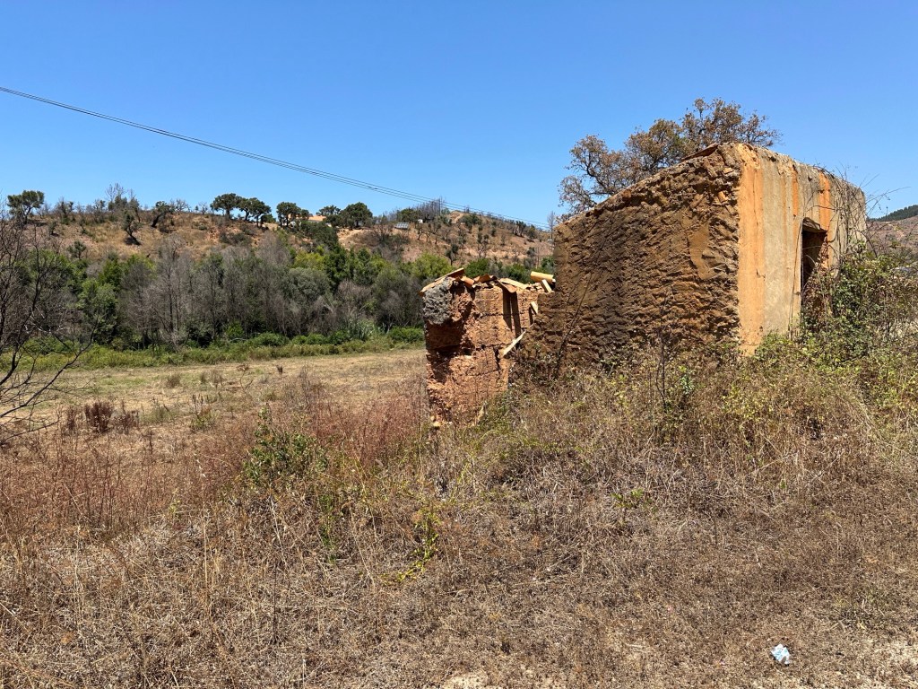 Vervallen oker-bruin gebouwtje in heuvels van Zambujeira de Cima