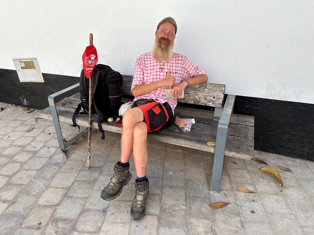 Pelgrim op bankje: rood-wit gestreept hemd, short, baard