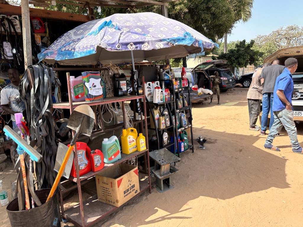 Stalletje met onderhoudsproducten voor auto’s in ongeplaveide straat 