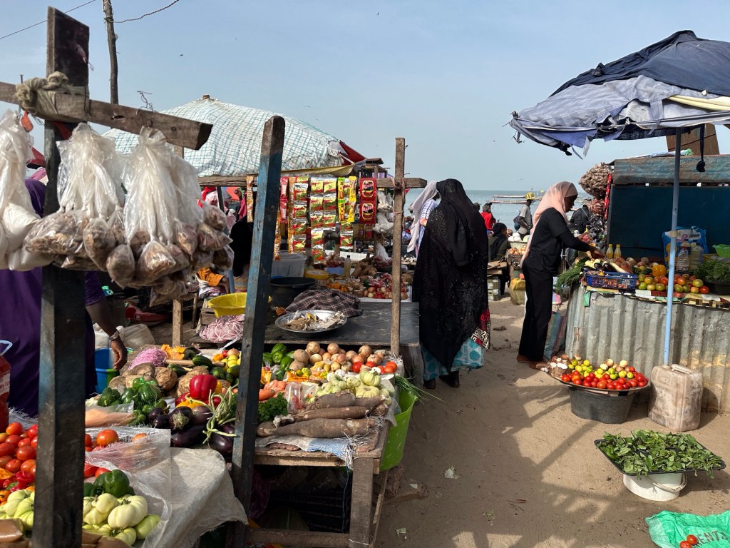 Kraampjes met groenten en fruit en zwart-gesluierde vrouw