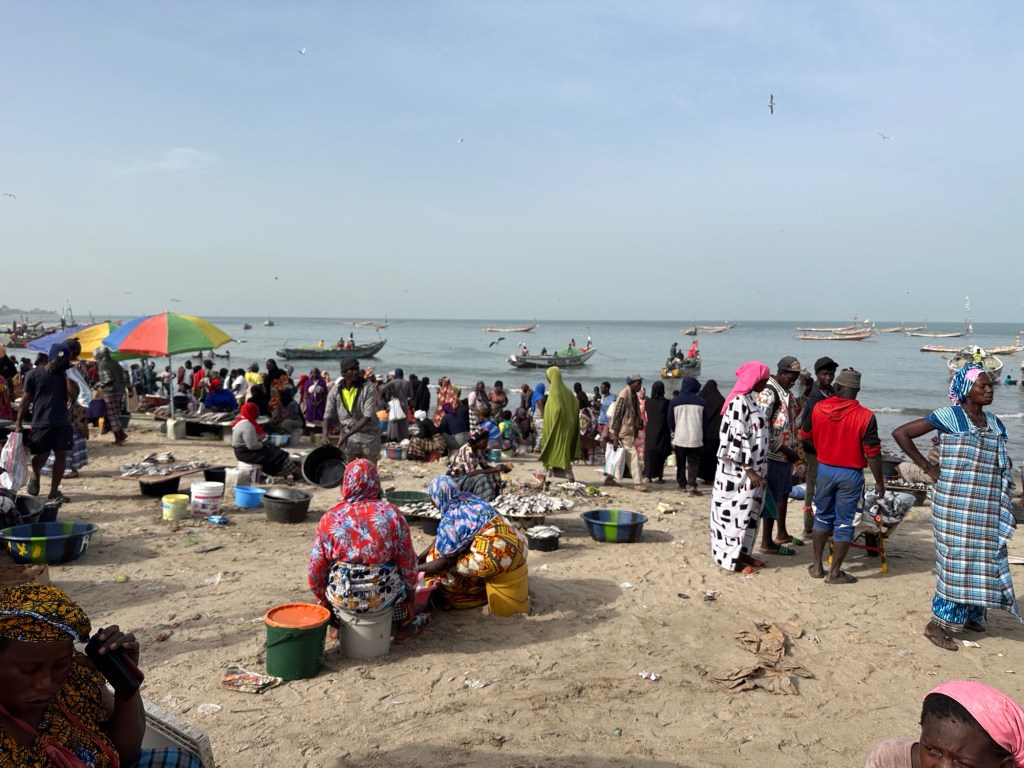 Mensenmassa inveelkleurige kledij op het strand van Tanji en kijkend naar de ze