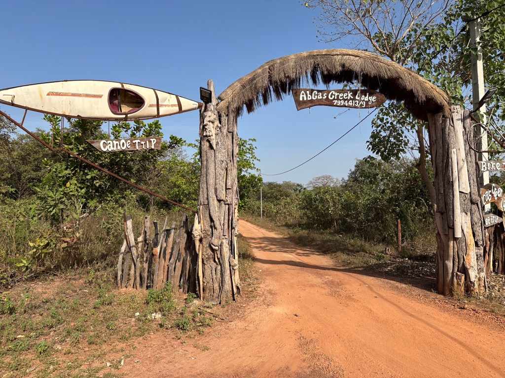 Toegangsweg tot Abca’s Creek Lodge met houten bord over de weg