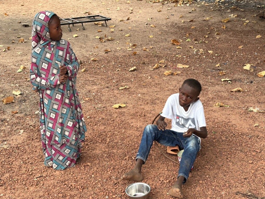 Meisje in traditionele klederdracht en jongetje met zelfgemaakt muziekinstrument 