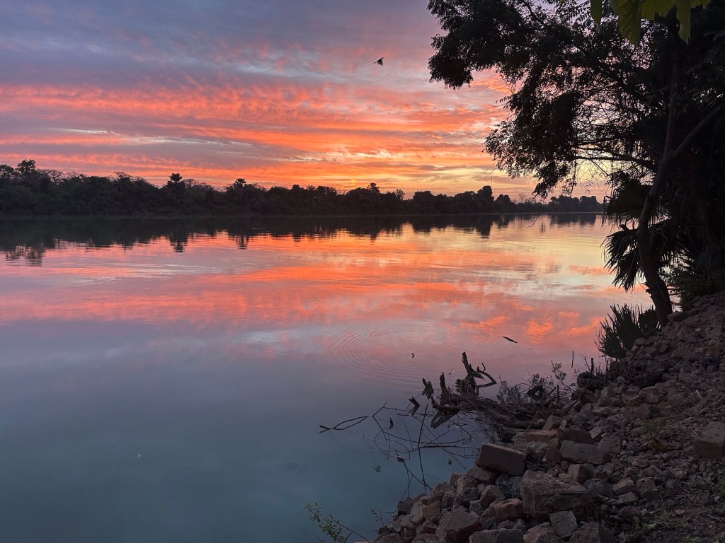 Oranje-rode hemel weerspiegeld in de Gambia-rivier