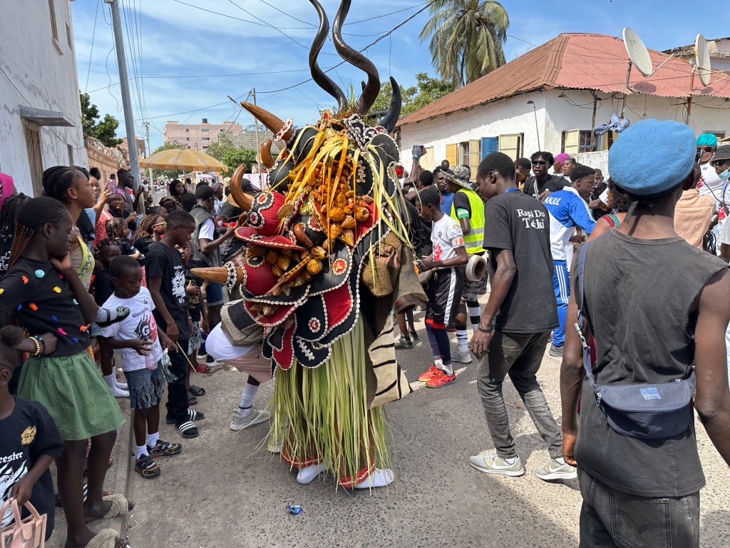 Dansende persoon met groot traditioneel masker. 