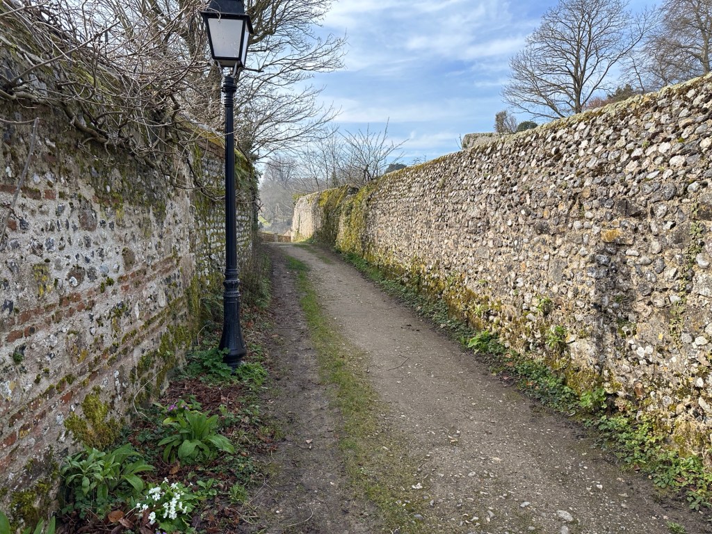 Smal oud straatje met hoge oude muren langs weerszijden
