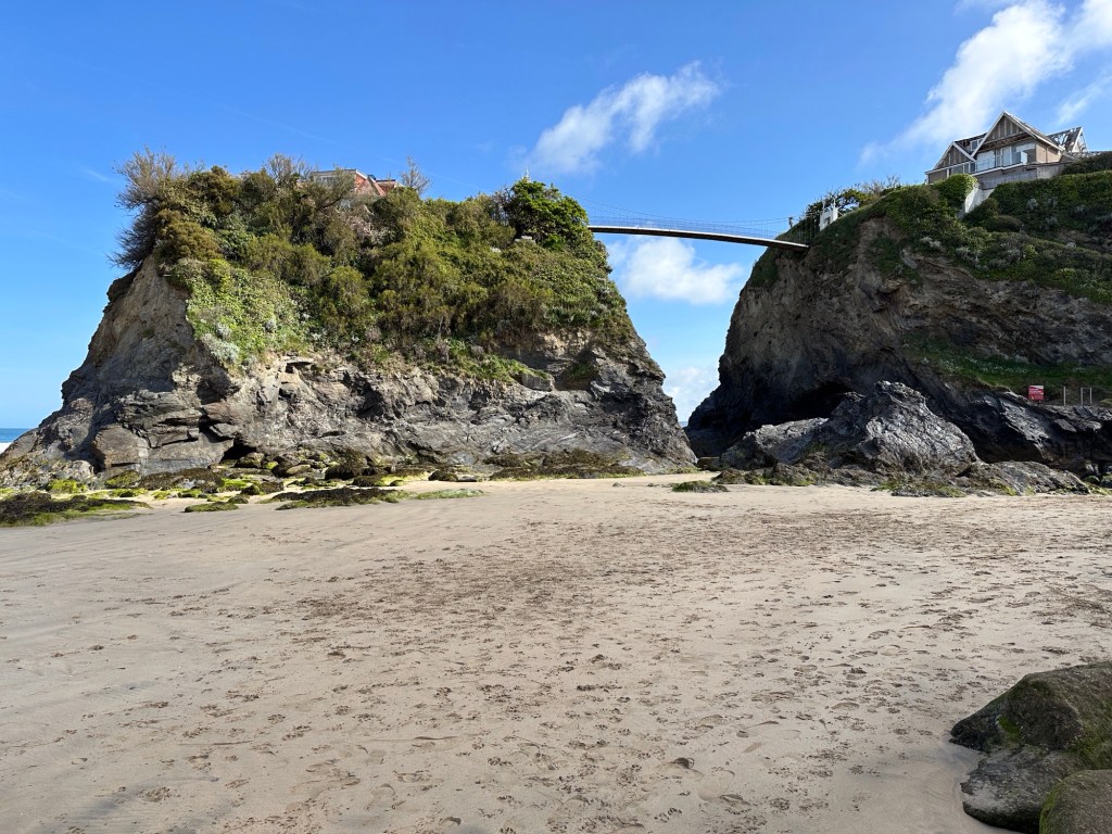 Towan Beach vanaf strandniveau met zicht op rotsen en voetgangersbrug naar The Island House