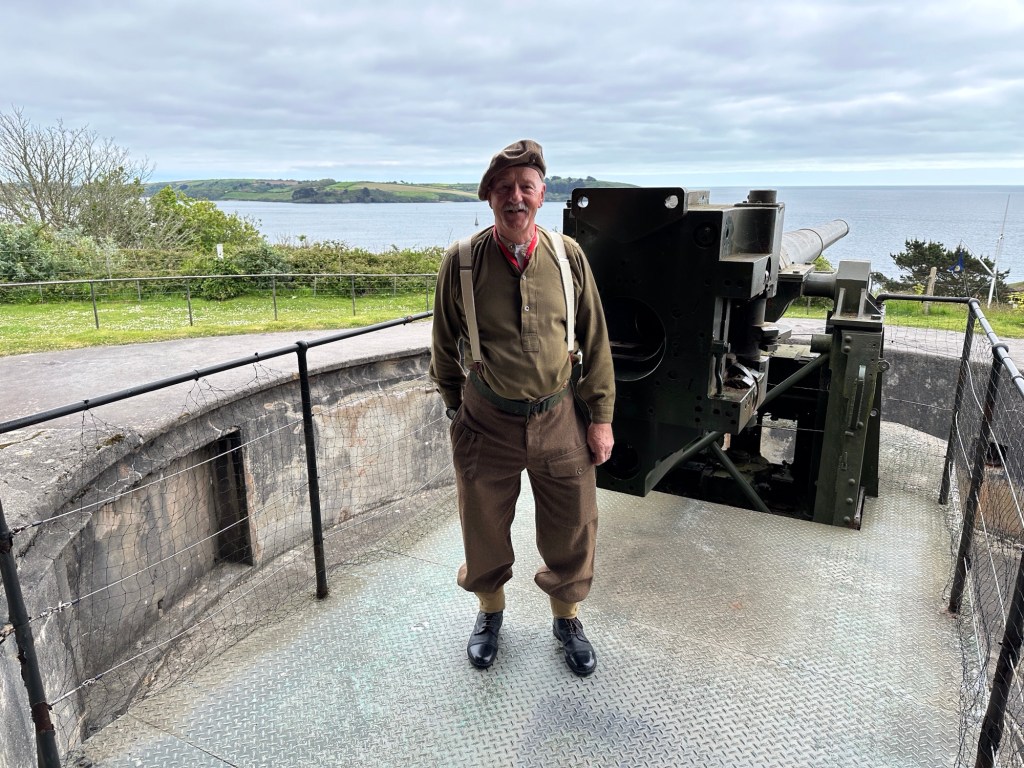 Gids in soldatenuniform voor WO II kanon in Pendennis Castle