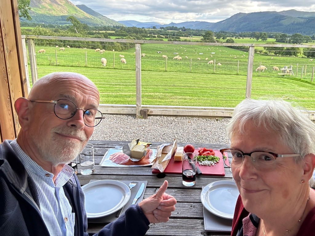 Toeristen eten gerookte zalm voor zonnig berglandschap. 