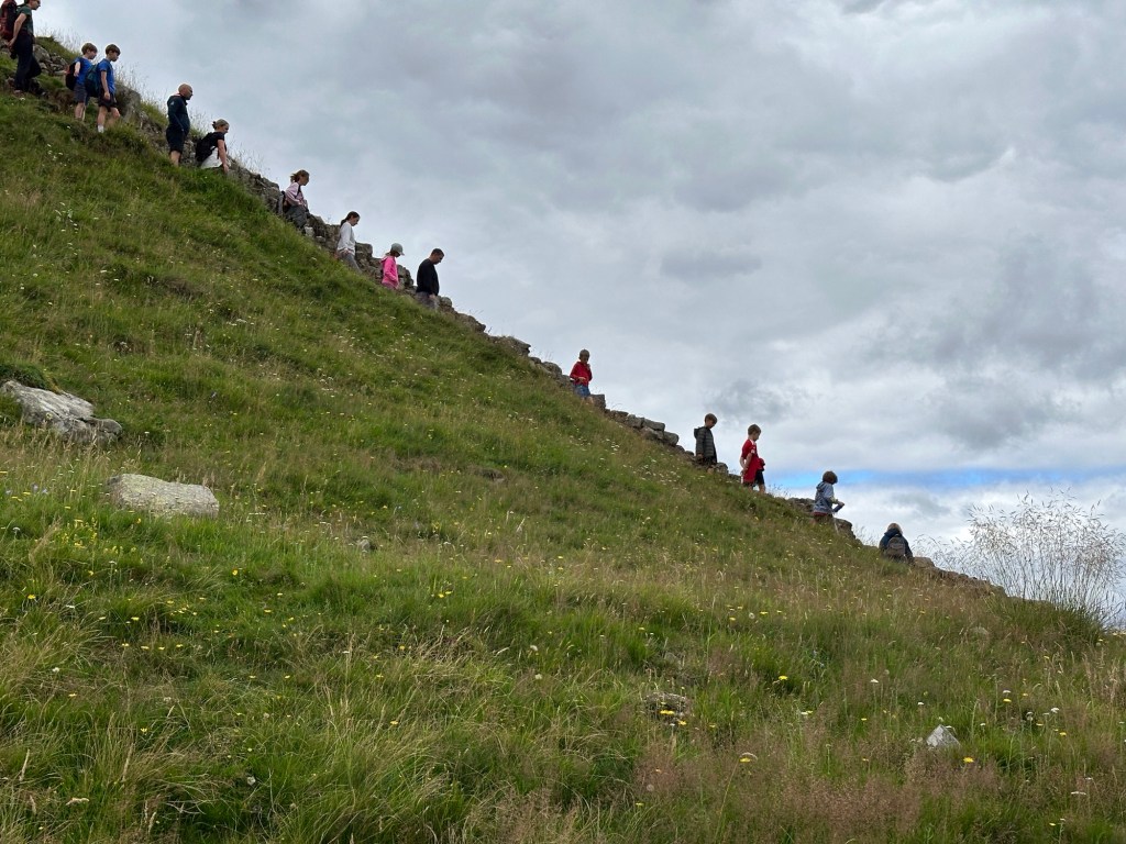 File van mensen op dalende berghelling. 