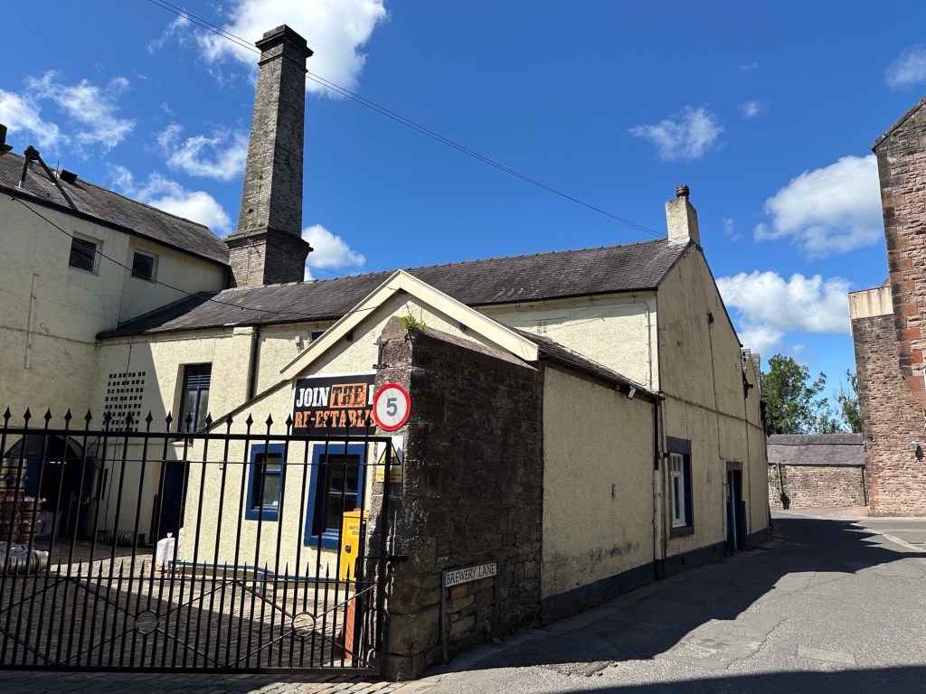 Industriële gebouwen met hoge schouw. 