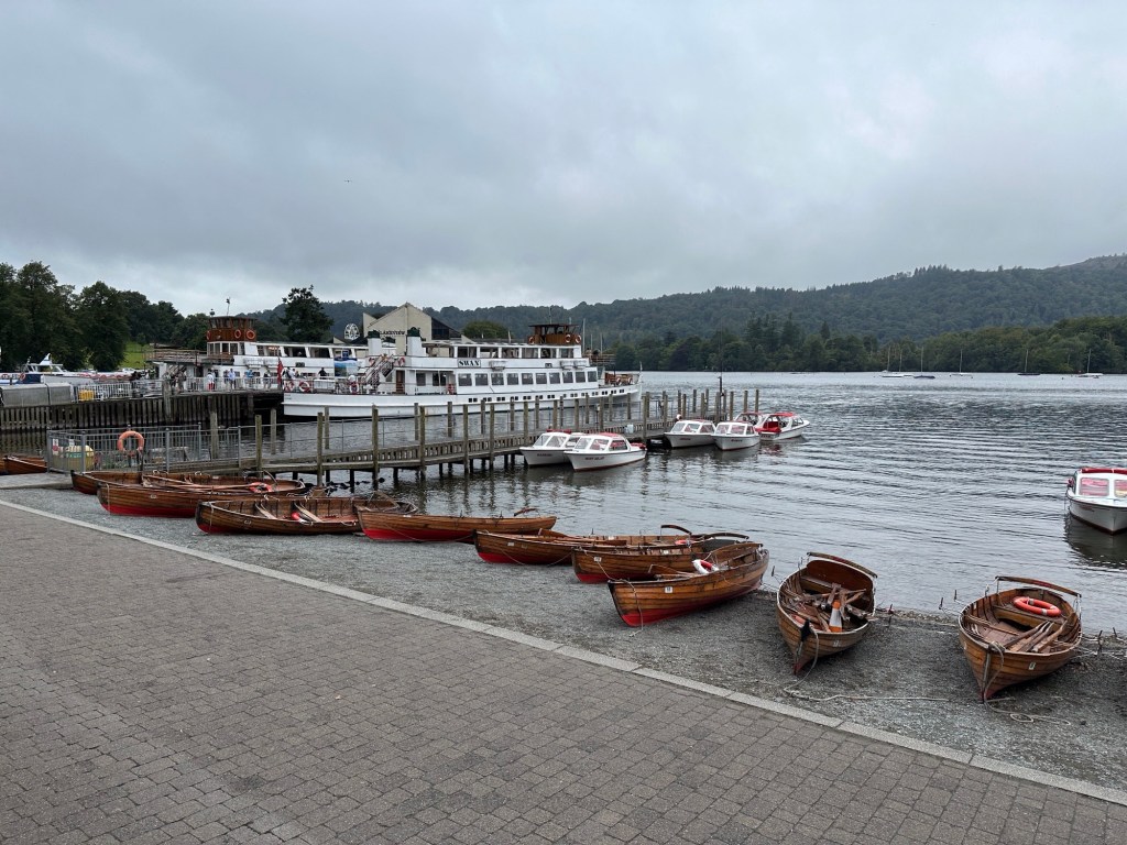 Meer met kleine bootjes en een grote, witte passagiersboot. 
