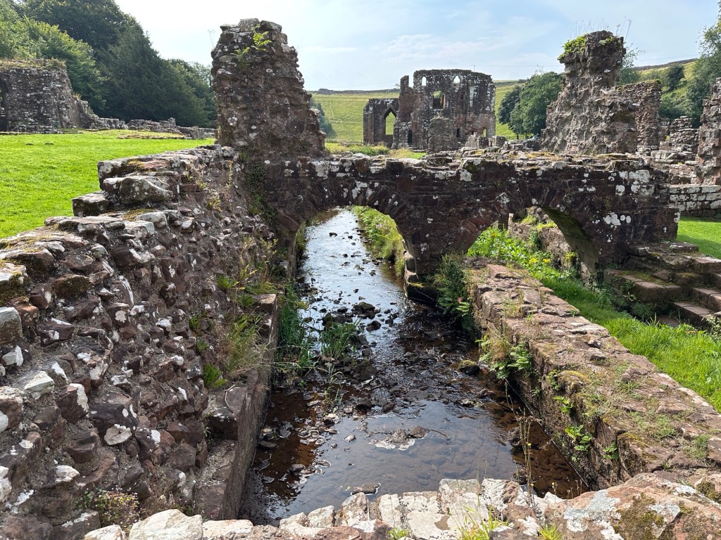 Ruïnes langs beide kanten van een kleine rivier. 