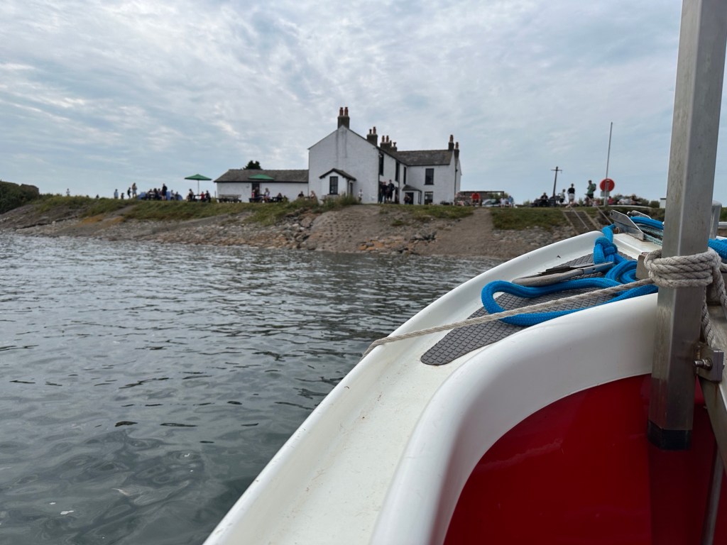 Wit huis op eiland gezien vanaf overzetbootje. 