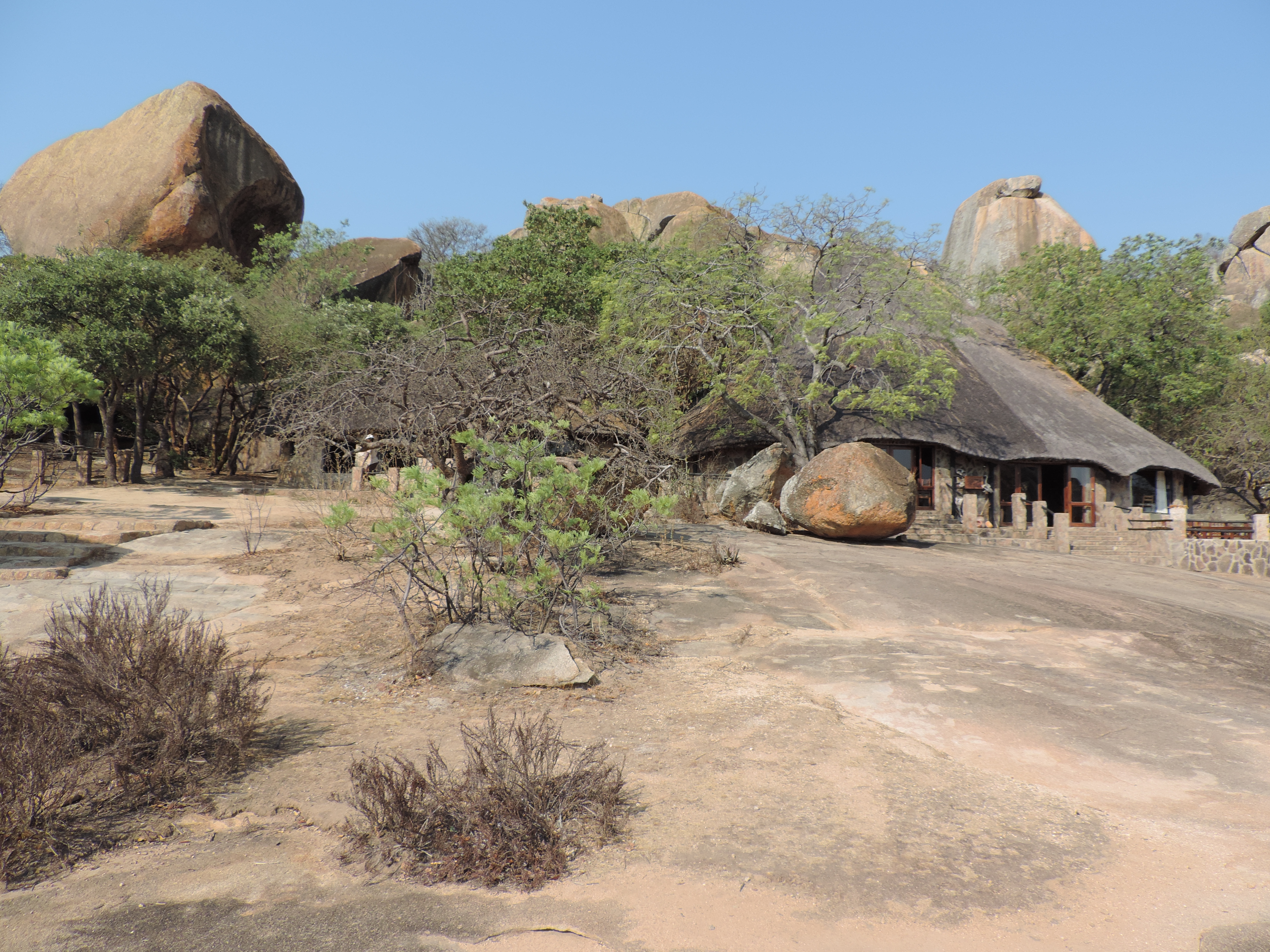Rotsblokken en rondavels verscholen in het groen.