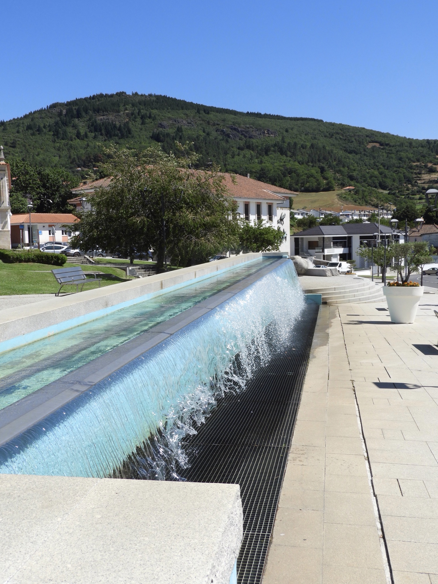 Lange waterbak waaruit water naar beneden stroomt over de ganse lengte.