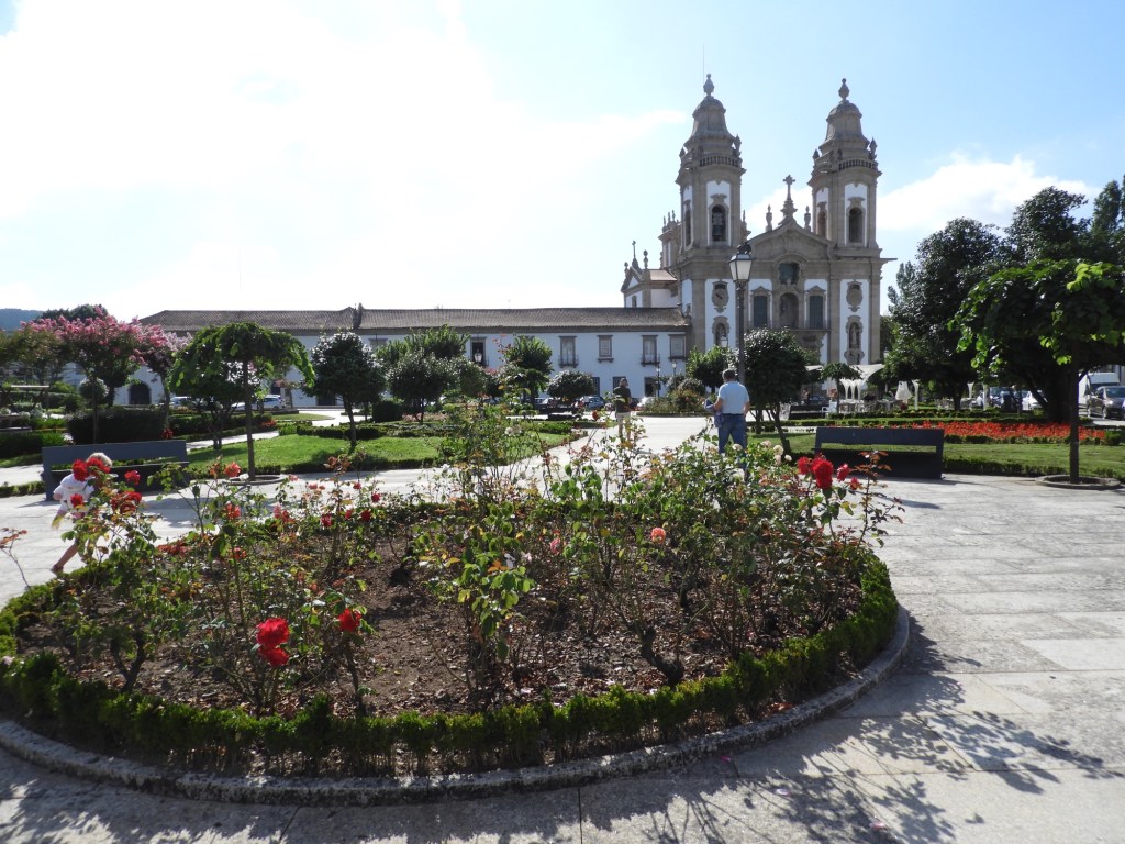 Plein met bloemperken en kerk van Cabeceiras. 