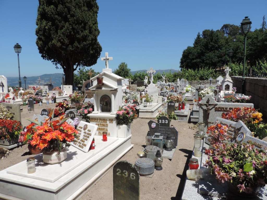 Witte graven en grafkapellen met veel bloemen.
