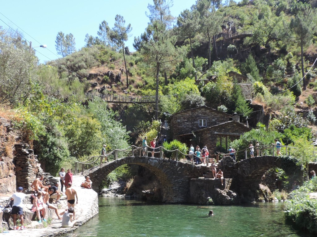 Zwemmers in riviertje en boogbrugjes.