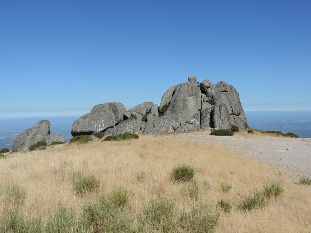 Gestapelde rotsblokken op bruing grasveld.
