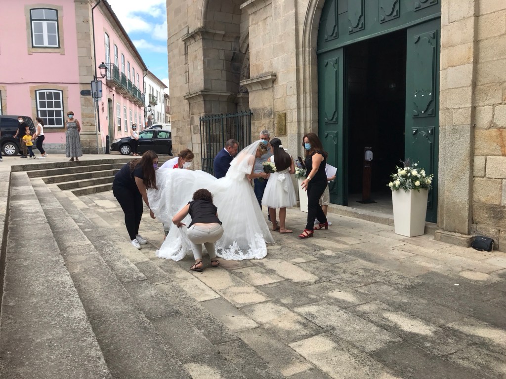 Bruid met lange sleep en bruidsmeisjes. 