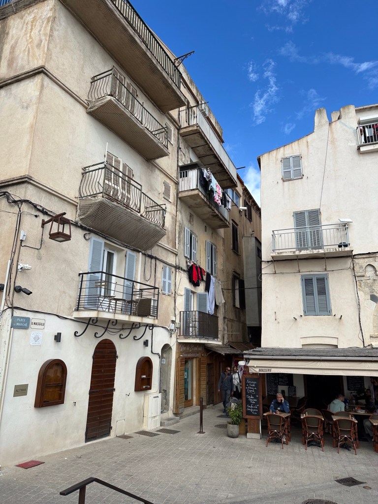 Drie verdiepingen hoge huizen met buiten hangend wasgoed. 