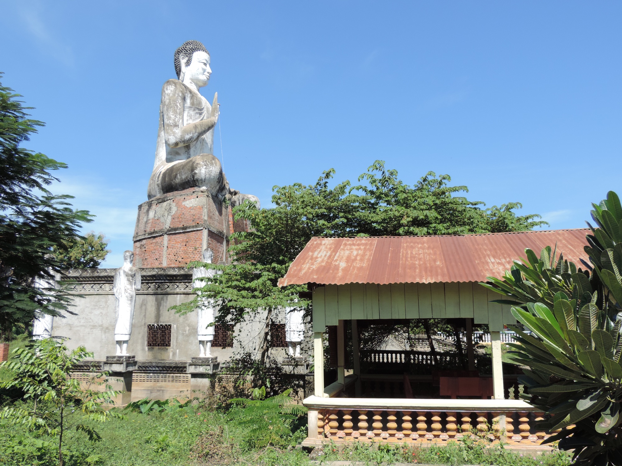 Groot Bouddha-beeld voor hangar met golfplaten dak